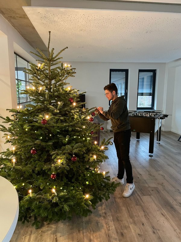 Unsere Azubi Justin schmückt unseren Weihnachtsbaum in der Cafete. Euch auch eine schöne Adventszeit :-).